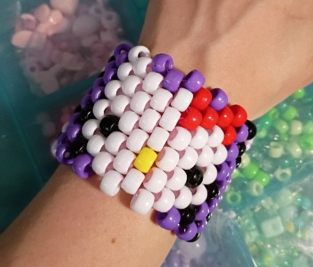 A Kandi cuff bracelet of hello kitty's face